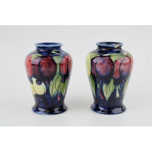 Two Moorcroft Wisteria Plum vases, both chipped, 9.5cm tall.