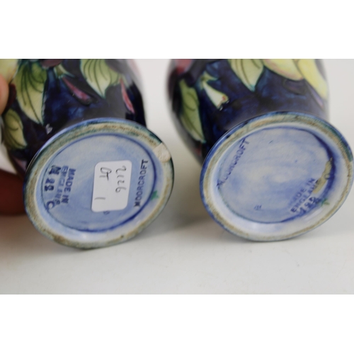 60 - Two Moorcroft Wisteria Plum vases, both chipped, 9.5cm tall.