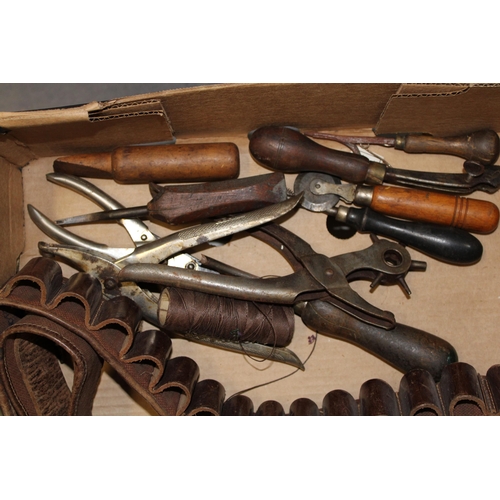 319 - A collection of vintage leather workers tools together with a vintage leather cartridge belt. (Qty)