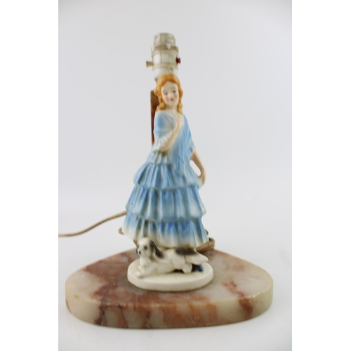 71 - A soapstone lamp base with ceramic figure of lady with dog. Height 28cm.