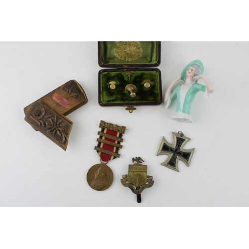 295 - A collection of items to include a ceramic pin doll, a snuff box, a pair of medals, a military cap b... 