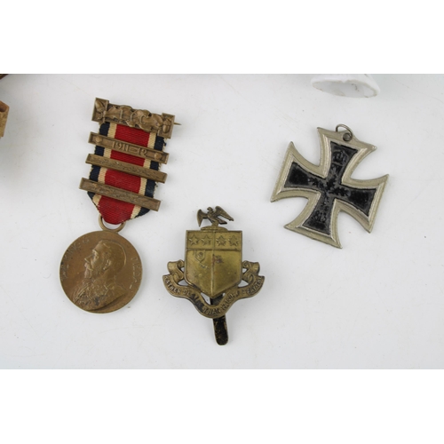 295 - A collection of items to include a ceramic pin doll, a snuff box, a pair of medals, a military cap b... 