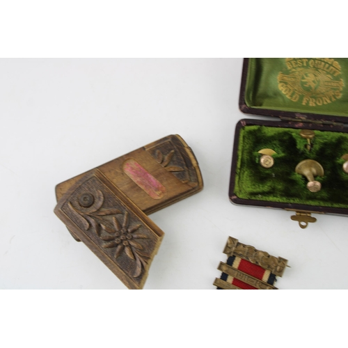 295 - A collection of items to include a ceramic pin doll, a snuff box, a pair of medals, a military cap b... 