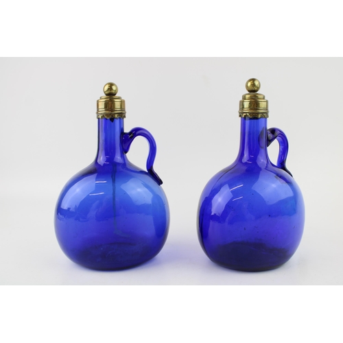 296 - A pair of Victorian Bristol blue glass decanters, curved handles, brass stopper and rims, 20.5cm tal... 