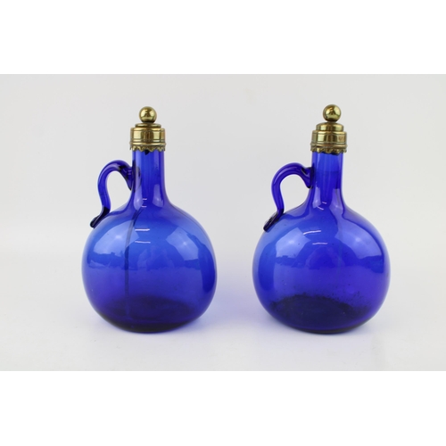 296 - A pair of Victorian Bristol blue glass decanters, curved handles, brass stopper and rims, 20.5cm tal... 