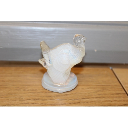 297 - Lalique opalescent figure of a turkey, circular base, signed to base, 6cm tall.