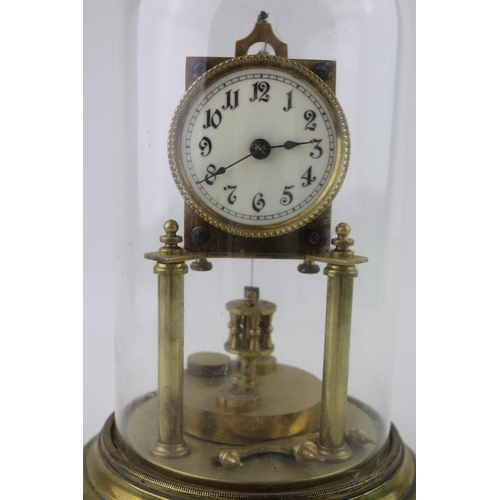 329 - An anniversary clock with brass base and glass dome. White ceramic dial with Arabic numerals.  Heigh... 