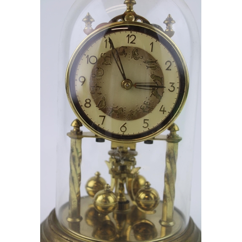 330 - An anniversary clock with brass base and glass dome.  Dial decorated with signs of the zodiac.  Heig... 