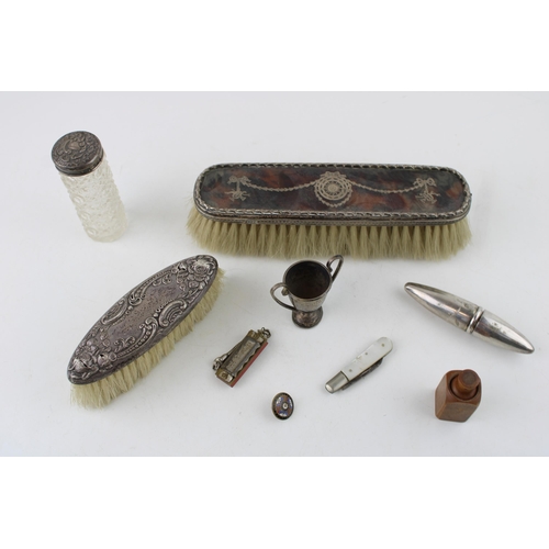 552 - A collection of early c20th sterling silver brushes, a small trophy, silver blade fruit knife and bo... 