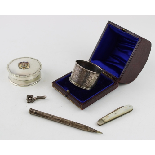 557 - A collection of silver items to include napkin ring, menu holder, SS Oronsay pill box, a silver blad... 