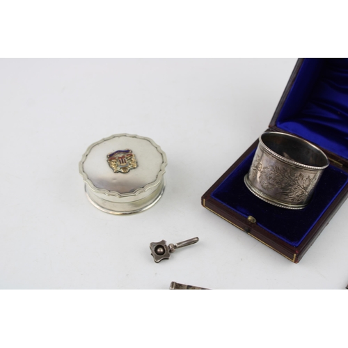 557 - A collection of silver items to include napkin ring, menu holder, SS Oronsay pill box, a silver blad... 