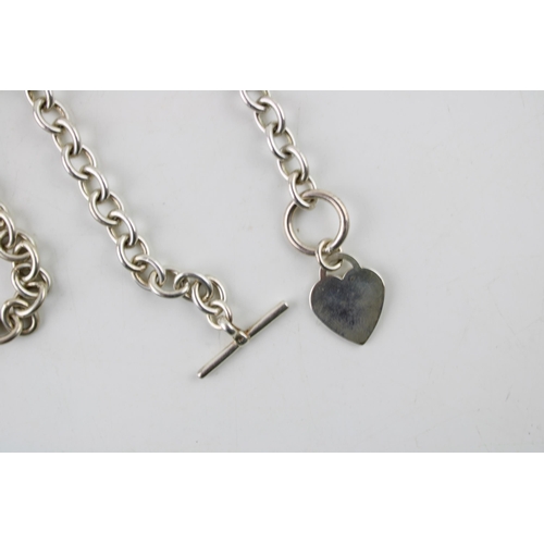 573 - A silver Tiffany style necklace in sterling silver with T bar and heart shaped charm. Length 46.5cm.... 