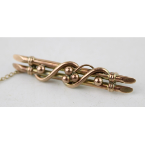 634 - A 9ct yellow gold bar brooch with safety chain. Gross weight 2.8g