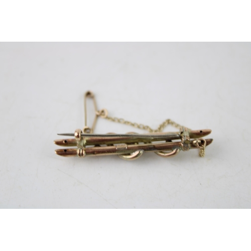 634 - A 9ct yellow gold bar brooch with safety chain. Gross weight 2.8g