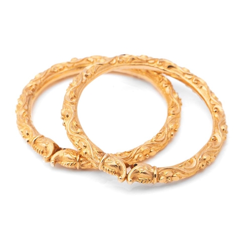 400 - A pair of vintage Indian gold bangles, each modelled with dolphin head finials, unmarked but testing...