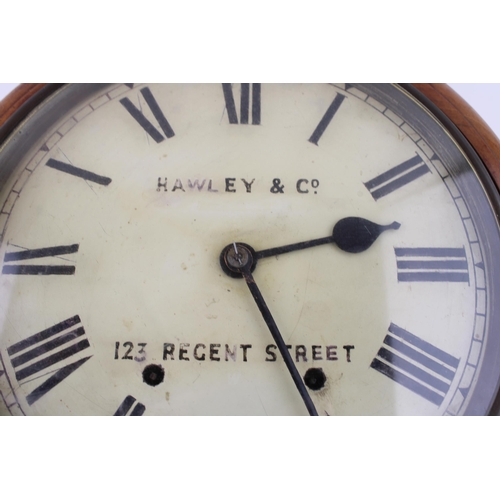 35 - An oak cased wall clock / school clock. Brass bezel with white dial and Roman numerals, HAWLEY & Co.... 