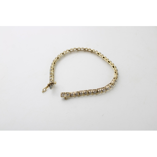 423 - A 10ct gold and diamond tennis bracelet, of twenty two panels each set with two diamonds, 6.4g, 18cm... 