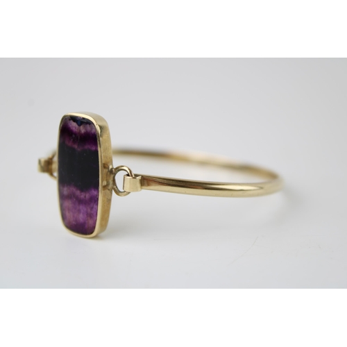 427 - A 9ct gold and Blue John bangle, the shaped rectangular lozenge of Blue John with banded striation, ... 