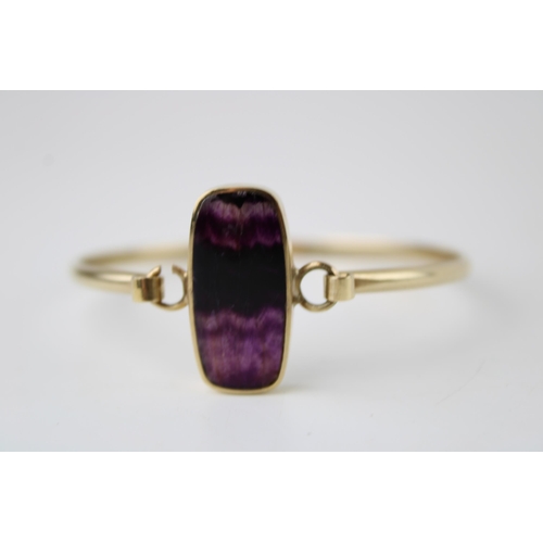 427 - A 9ct gold and Blue John bangle, the shaped rectangular lozenge of Blue John with banded striation, ... 