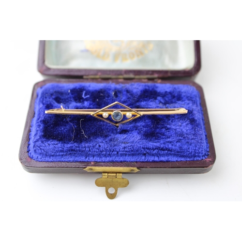 445 - A cased 14ct gold Art Deco style bar brooch set pearls and blue stone. Width 57mm. Weight 2.4g.