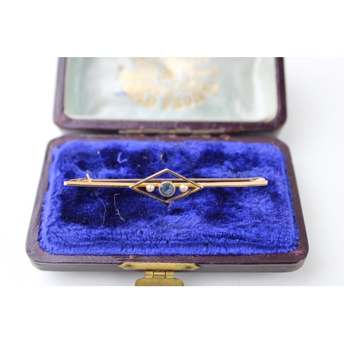 445 - A cased 14ct gold Art Deco style bar brooch set pearls and blue stone. Width 57mm. Weight 2.4g.