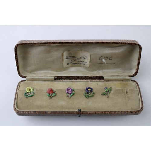 446 - A set of five silver button clips with enamelled decoration, floral design, in fitted case, 1 missin... 