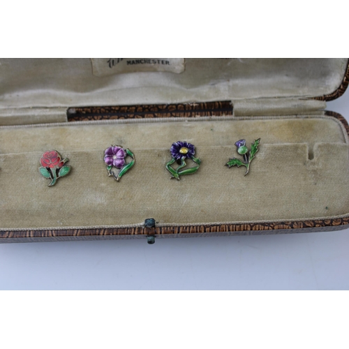 446 - A set of five silver button clips with enamelled decoration, floral design, in fitted case, 1 missin... 