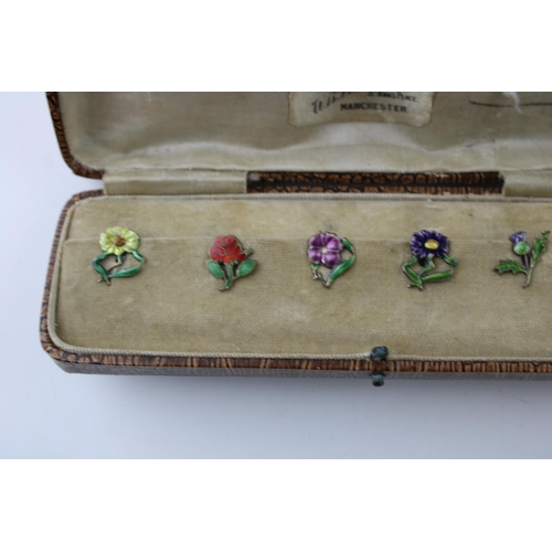 446 - A set of five silver button clips with enamelled decoration, floral design, in fitted case, 1 missin... 