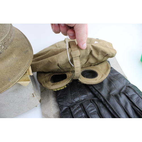 55 - An early 20th century flying / motoring hat, two pairs of goggles, a pair of leather gloves together... 