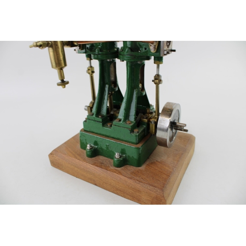 69 - A Stuart Turner stationary two piston marine engine mounted on a wooden plinth. Height 17.5cm.