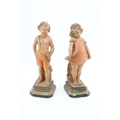 171 - A pair of continental Art Deco chalk ware figures in the form of a boy and a girl. Height 32cm.