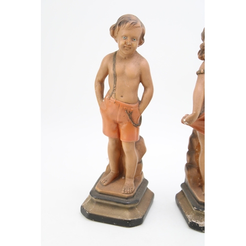 171 - A pair of continental Art Deco chalk ware figures in the form of a boy and a girl. Height 32cm.