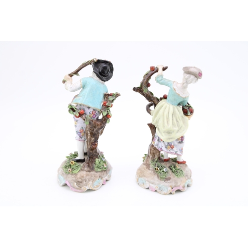 223 - A pair of antique porcelain figures, probably Meissen, of a couple collecting apples (2), faint blue... 