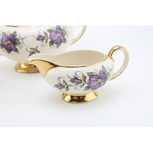 311 - Sadler purple flower tea set to include a teapot, lidded sugar and milk jug (3).