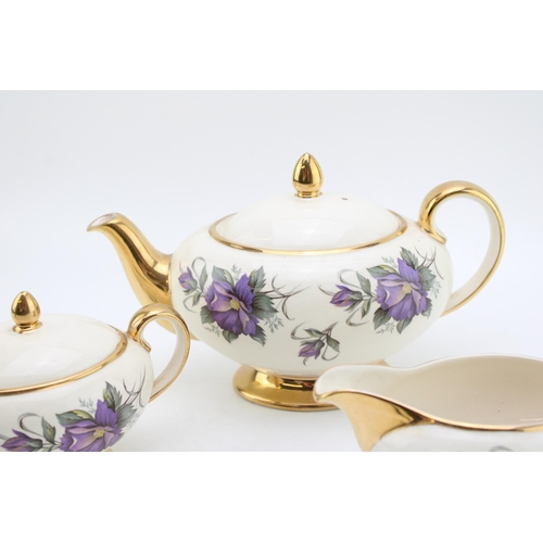 311 - Sadler purple flower tea set to include a teapot, lidded sugar and milk jug (3).