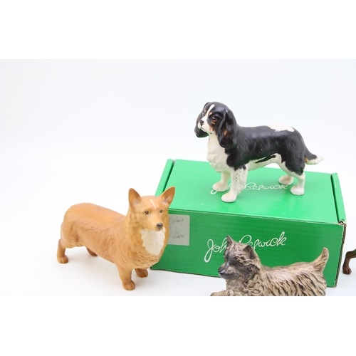 44 - Four Beswick large dogs to include a Corgi, a Doberman, a boxed King Charles Spaniel and a Terrier (... 