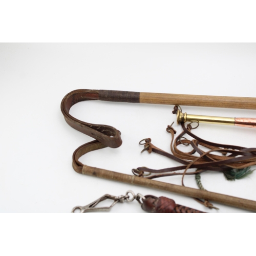 445 - A collection of Hunting accessories to include  a leather game hanger, two stag antler riding crops,... 