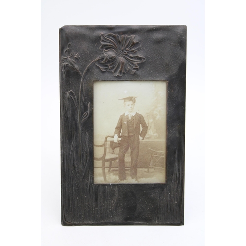 468 - An Art Nouveau copper photo frame with stylised flowers to left hand side of frame. 26cm x 16.5cm.