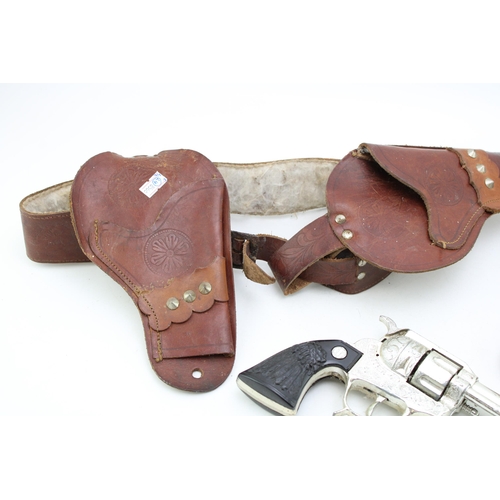 492 - Two vintage toy gun holsters together with a BCM Frontier cap gun. (2)