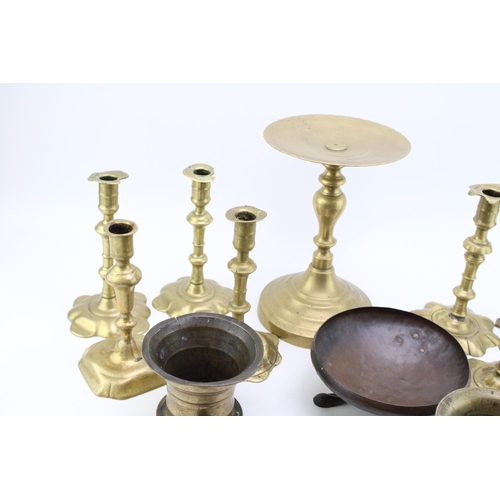 543 - A collection of c18th & c19th brass candlesticks and other brass items including mortars, a stand an... 