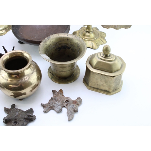 543 - A collection of c18th & c19th brass candlesticks and other brass items including mortars, a stand an... 