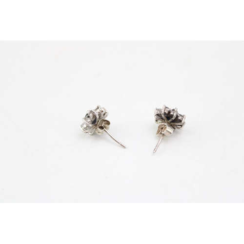 636 - A near pair of 9ct white gold, diamond and sapphire earrings of flowerhead form, 2.0g.