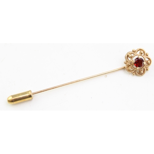 642 - A 9ct yellow gold stick pin set with garnet. Weight 2.6g.