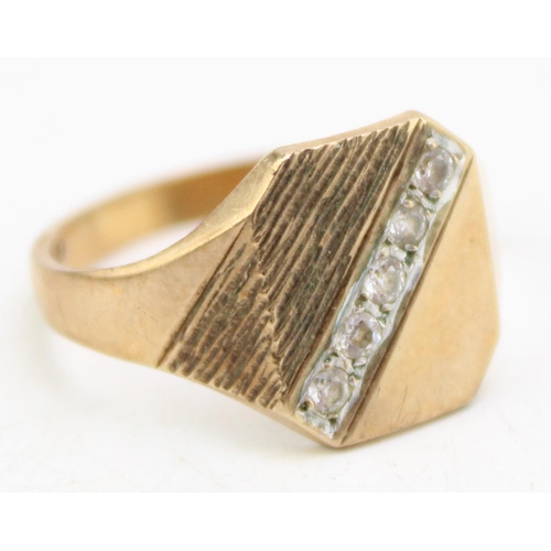 658 - A 9ct gold signet ring, the textured setting with five white stones, size Q, 3.9g.