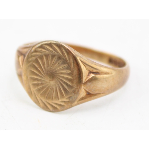 661 - A 9ct gold signet ring the oval plate with sunburst engraving, size S/T, 4.4g.