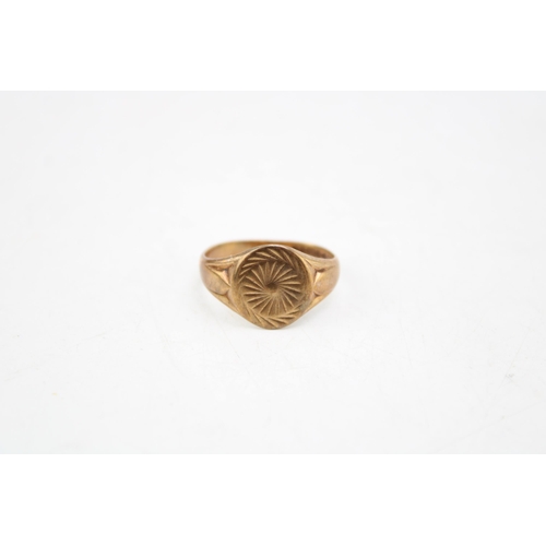 661 - A 9ct gold signet ring the oval plate with sunburst engraving, size S/T, 4.4g.