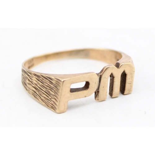 663 - A 9ct gold mid century brutalist design signet ring, the central emblem of initials 'PM', with bark ... 