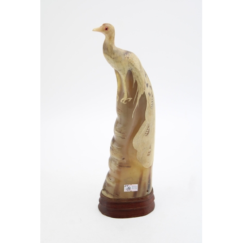 107 - A carved horn figure of a peacock mounted on wooden plinth. Height 31.5cm.