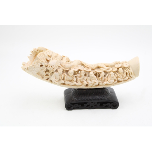 109 - A faux ivory / resin carved tusk. Height 17cm, width 29cm.