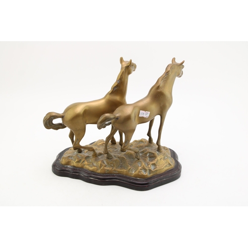 141 - A vintage brass statue of two horses mounted on plinth. Height 24cm.